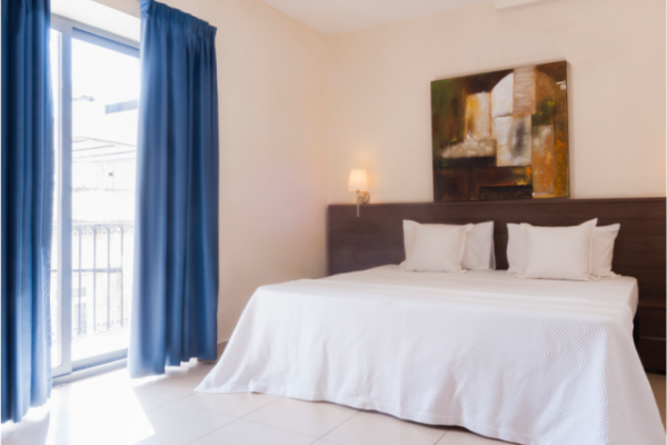 Blubay apartment's Seaview bedroom with a double bed and a big window