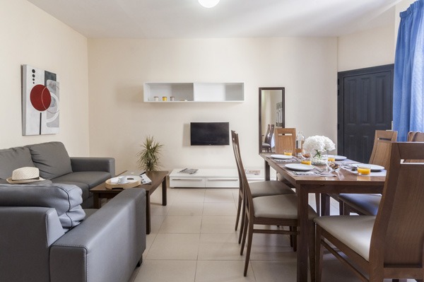Blubay apartment's living room equipped with dining table, sofa and tv