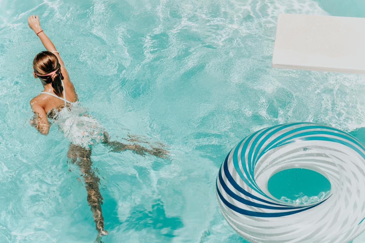 a woman is swimming in St hotel's outdoor pool and enjoying her vacation in Malta