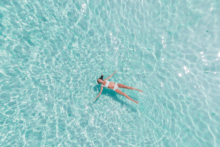 a woman is swimming in ST hotels pool and enjoying the water and sunshine