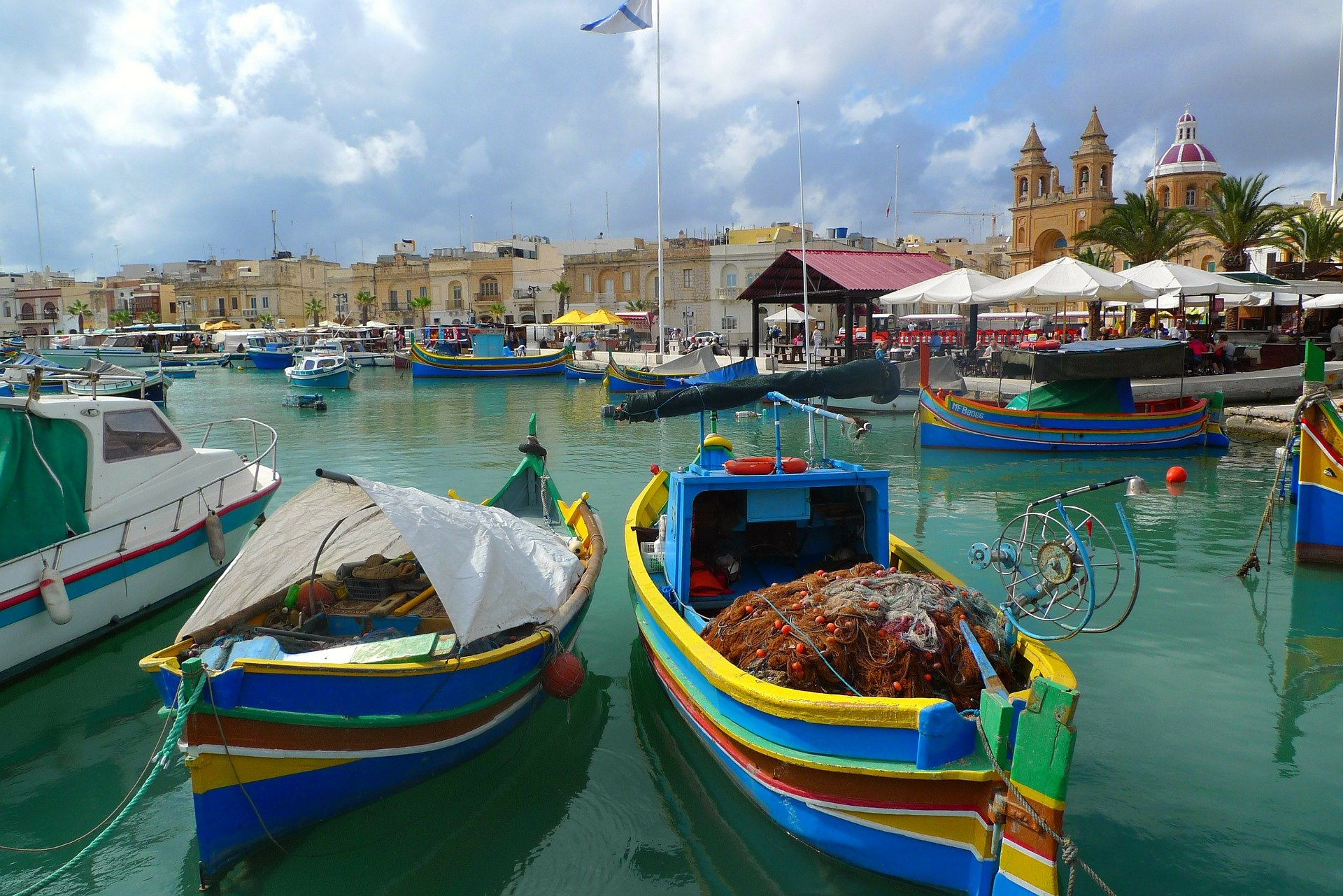 an image of Malta fishing village with some colorful boats and fishing equipment